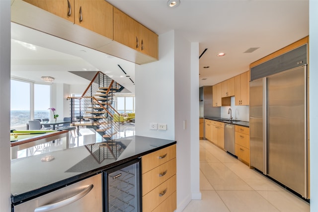 kitchen with stainless steel appliances, plenty of natural light, beverage cooler, and light tile patterned floors