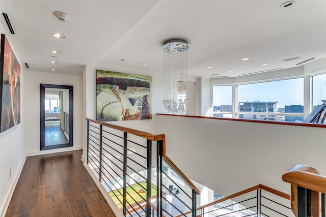 hall featuring an inviting chandelier, plenty of natural light, and dark hardwood / wood-style flooring