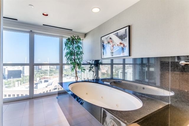 bathroom featuring a tub to relax in, a healthy amount of sunlight, and tile patterned flooring