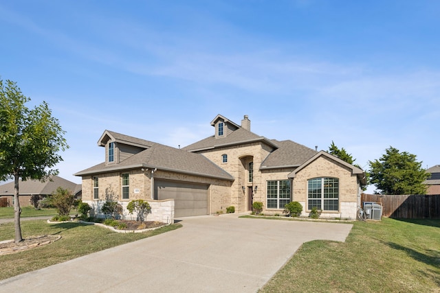 french country home featuring central AC unit, a garage, and a front lawn