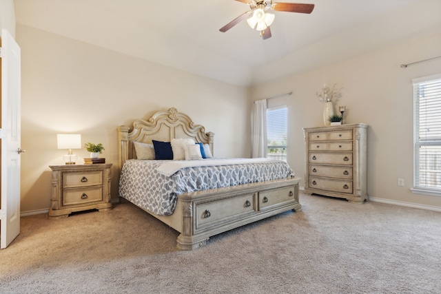 carpeted bedroom featuring multiple windows, ceiling fan, and vaulted ceiling