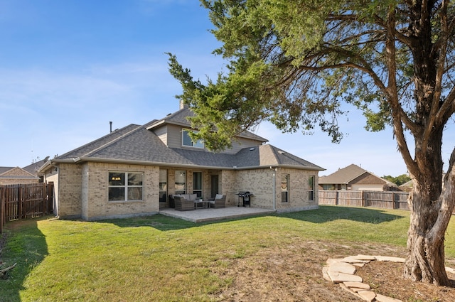 rear view of property with a yard and a patio area