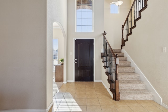 entrance foyer with light tile patterned floors and a high ceiling