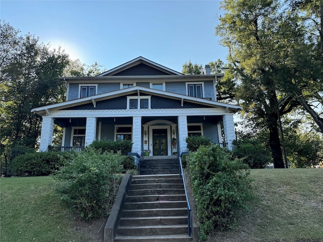 view of front of property with a front yard and covered porch