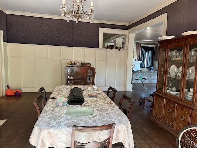 dining area featuring dark wood-type flooring, a notable chandelier, and ornamental molding