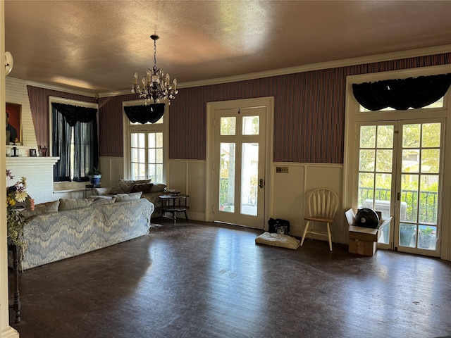 unfurnished living room with a wealth of natural light, a notable chandelier, crown molding, and dark hardwood / wood-style flooring