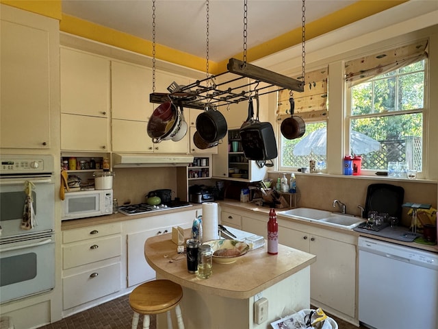 kitchen featuring white cabinetry, decorative light fixtures, and white appliances