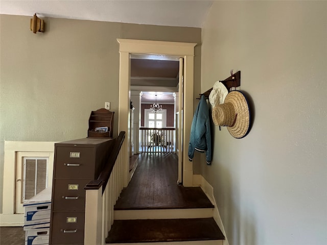 hallway with a notable chandelier and hardwood / wood-style flooring