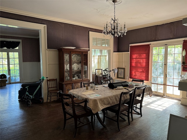 dining area with wood-type flooring, crown molding, and plenty of natural light