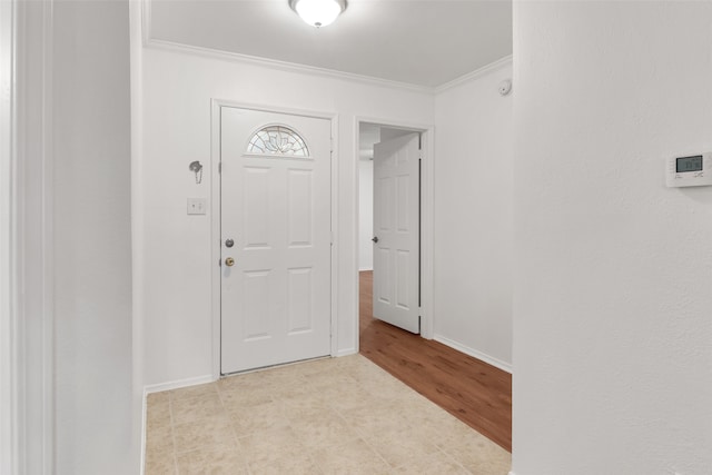 foyer entrance with light hardwood / wood-style flooring and ornamental molding