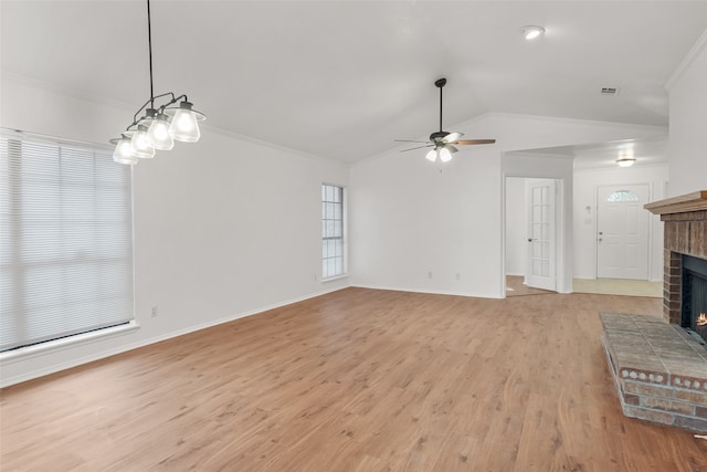 unfurnished living room with light hardwood / wood-style floors, a brick fireplace, ceiling fan, lofted ceiling, and crown molding