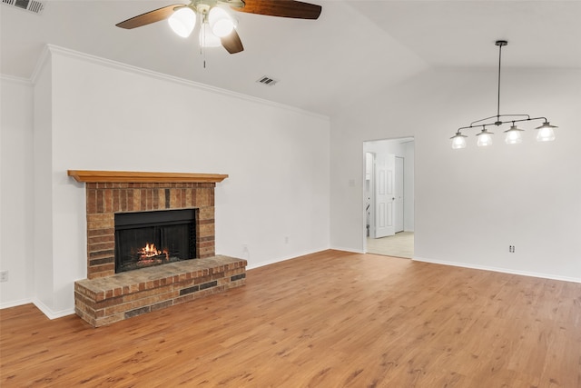 unfurnished living room with ceiling fan, a brick fireplace, light wood-type flooring, lofted ceiling, and crown molding