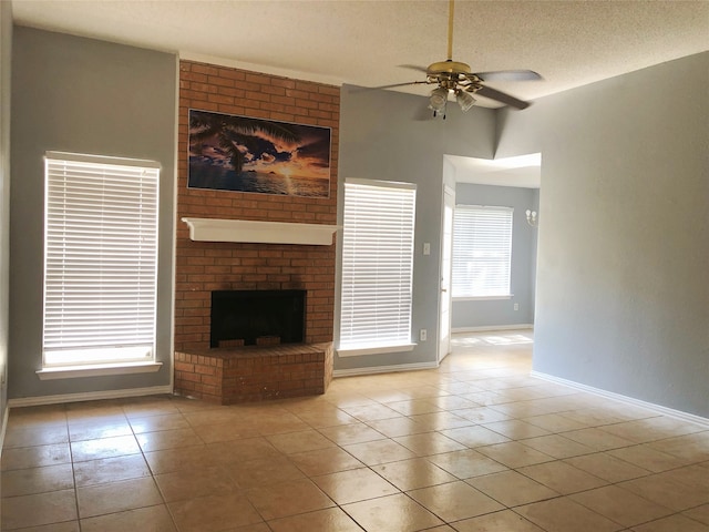 unfurnished living room featuring a fireplace, a textured ceiling, light tile patterned floors, and ceiling fan