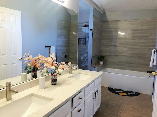 bathroom featuring tile patterned floors, vanity, tiled shower / bath, and a textured ceiling