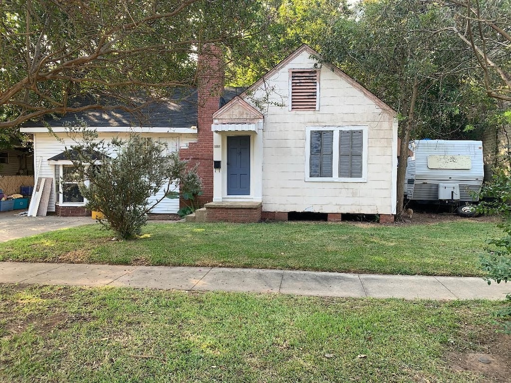 bungalow-style house featuring a front lawn