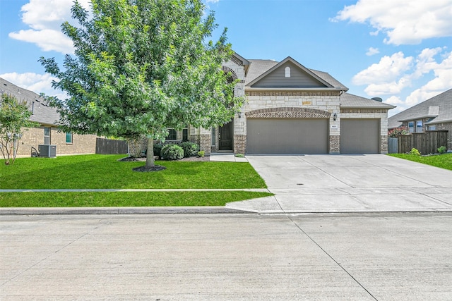 view of front of property featuring a front yard, cooling unit, and a garage