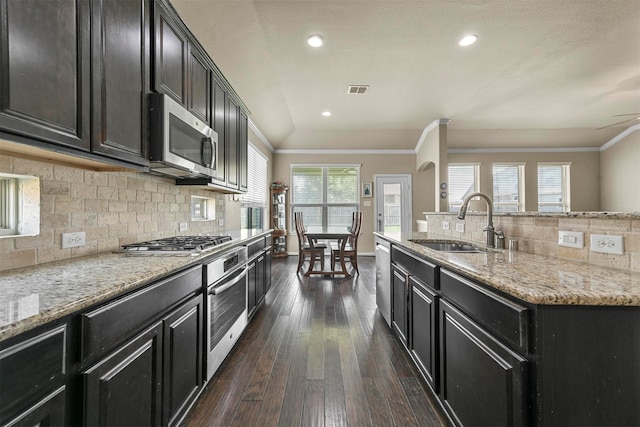 kitchen with sink, appliances with stainless steel finishes, dark hardwood / wood-style floors, and tasteful backsplash