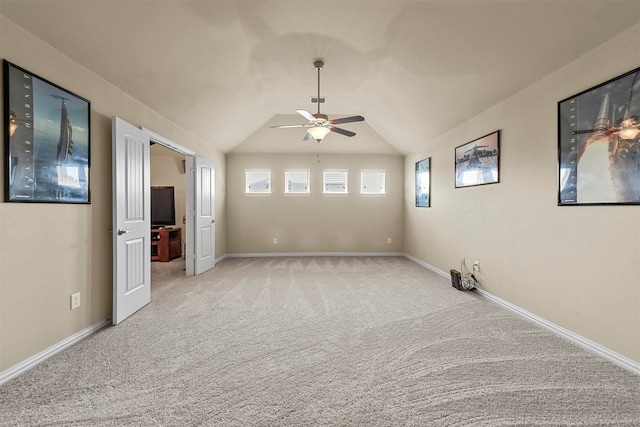 unfurnished room with light carpet, ceiling fan, and vaulted ceiling