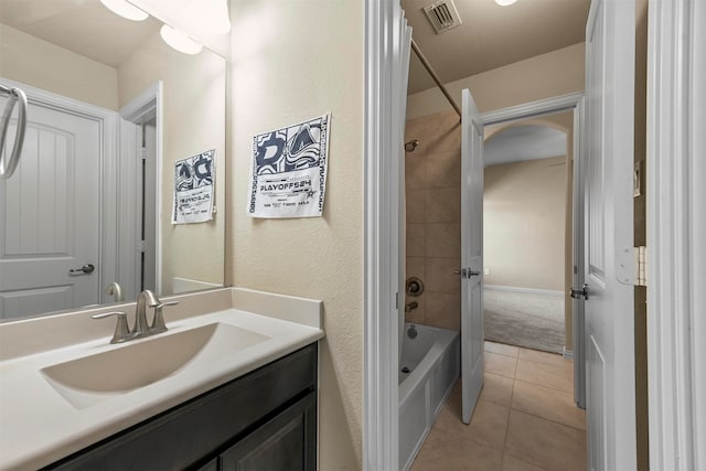 bathroom featuring vanity, tiled shower / bath combo, and tile patterned flooring