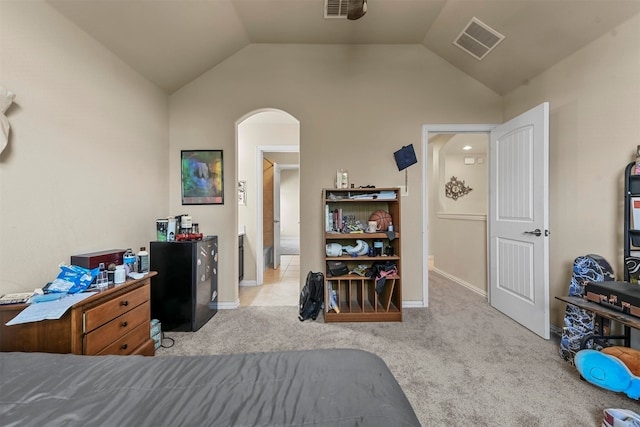 bedroom with light carpet, lofted ceiling, and black fridge