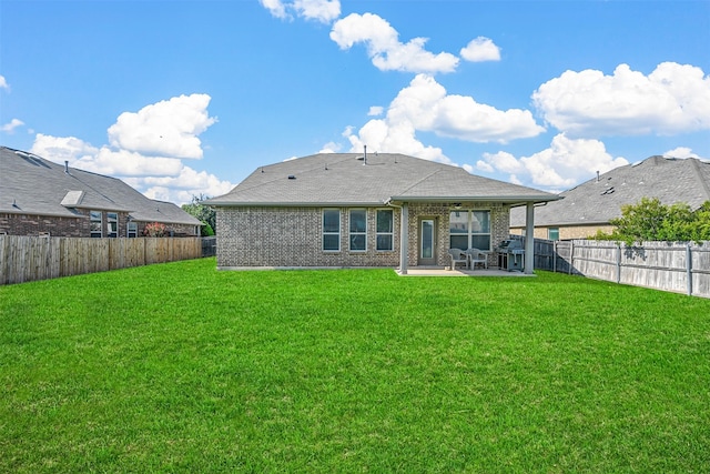 back of property with a patio area and a yard