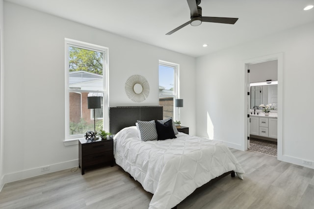 bedroom featuring light wood-type flooring, ceiling fan, and ensuite bathroom