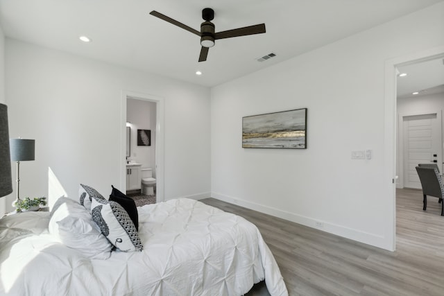 bedroom with hardwood / wood-style floors, connected bathroom, and ceiling fan