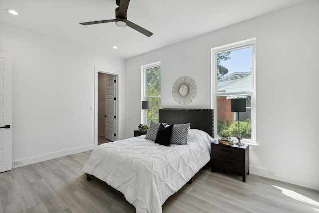 bedroom with ceiling fan, light wood-type flooring, and multiple windows