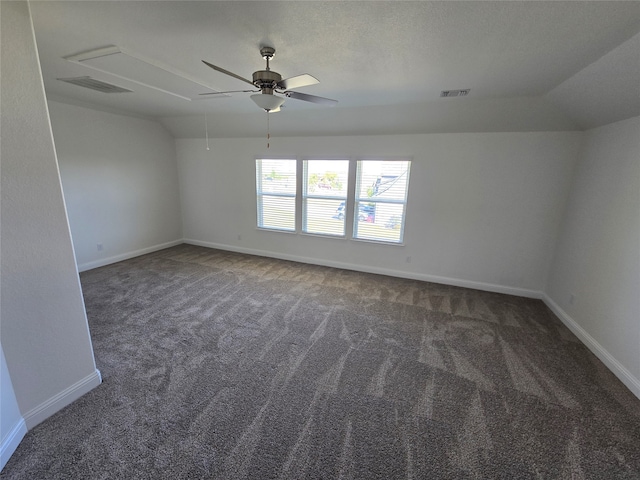 unfurnished room featuring lofted ceiling, dark carpet, and ceiling fan