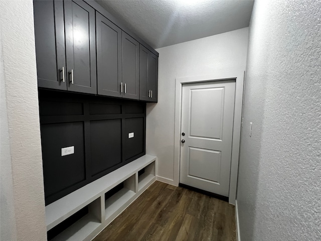 mudroom featuring dark wood-type flooring and a textured ceiling