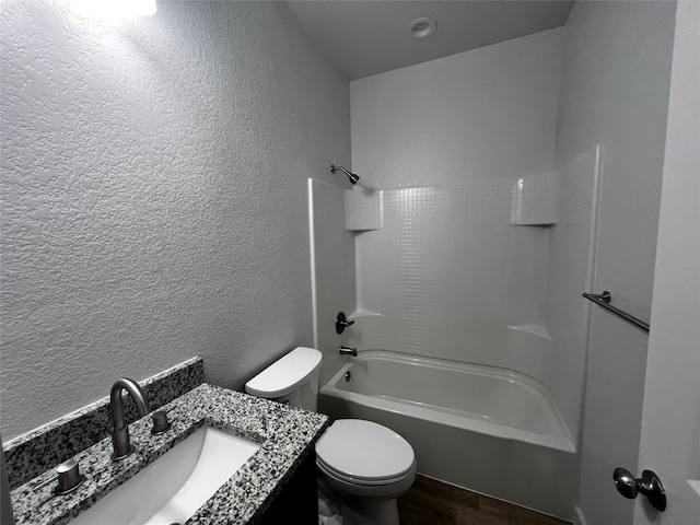 full bathroom with vanity, hardwood / wood-style floors, toilet, and washtub / shower combination