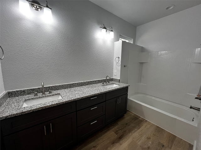 bathroom with bathing tub / shower combination, vanity, and wood-type flooring