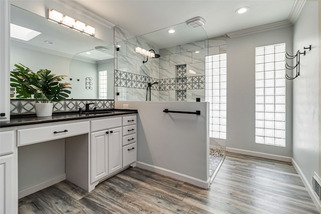 bathroom featuring vanity, a healthy amount of sunlight, a shower, and hardwood / wood-style floors