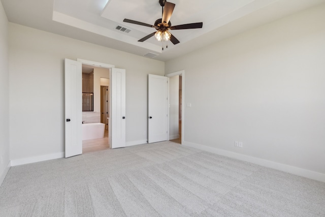 unfurnished bedroom with ensuite bathroom, ceiling fan, and light colored carpet