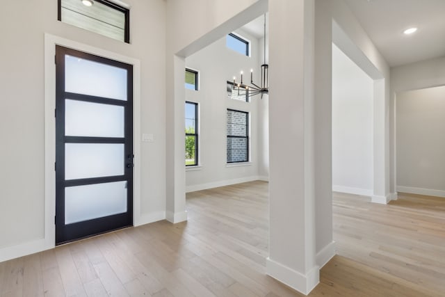 foyer entrance featuring an inviting chandelier and light wood-type flooring