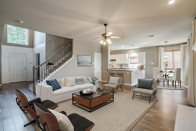 living room featuring ceiling fan, light wood-type flooring, and a healthy amount of sunlight