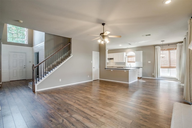 unfurnished living room featuring ceiling fan, plenty of natural light, and dark hardwood / wood-style floors