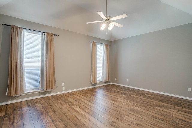 empty room with ceiling fan, light hardwood / wood-style flooring, vaulted ceiling, and a wealth of natural light