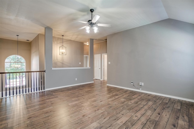 spare room featuring ceiling fan with notable chandelier, lofted ceiling, and wood-type flooring