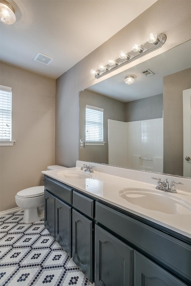 bathroom with vanity, a wealth of natural light, and toilet