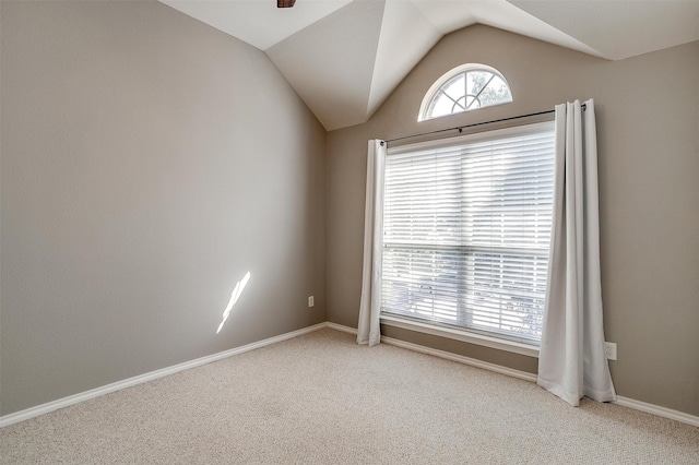 carpeted empty room featuring ceiling fan and vaulted ceiling