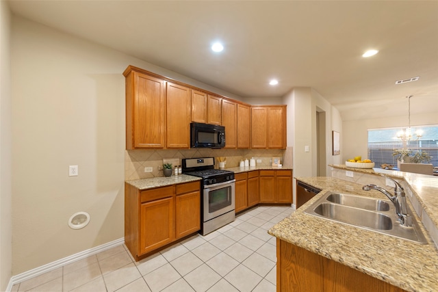 kitchen with pendant lighting, sink, tasteful backsplash, stainless steel appliances, and a notable chandelier