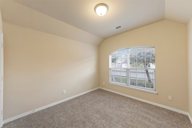 unfurnished room featuring lofted ceiling and carpet