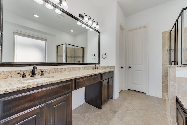 bathroom featuring walk in shower, vanity, and tile patterned flooring