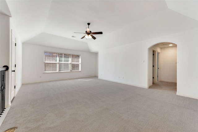 spare room featuring light carpet, lofted ceiling, and ceiling fan