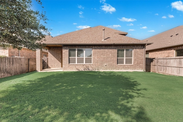 5625 Granada Dr, Mckinney, TX 75071 - rear view of house featuring a fenced backyard, brick siding, roof with shingles, and a lawn