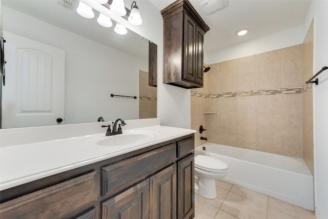 full bathroom with tile patterned flooring, tiled shower / bath, vanity, and toilet