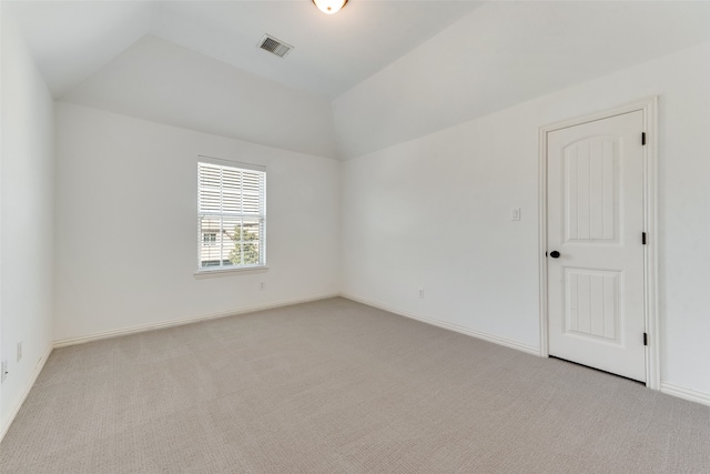 carpeted empty room with lofted ceiling