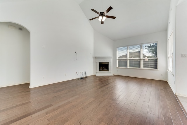 unfurnished living room featuring wood-type flooring, high vaulted ceiling, and ceiling fan