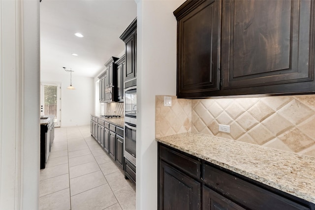 5625 Granada Dr, Mckinney, TX 75071 - kitchen with light stone counters, dark brown cabinetry, light tile patterned floors, and tasteful backsplash